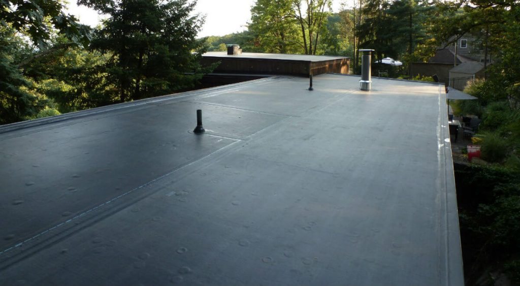 Flat roof installation with vent pipe penetrations